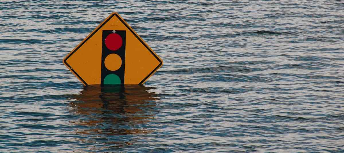 Water floods the area up to the traffic light sign