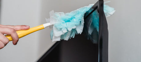 Person dusting TV with Swiffer